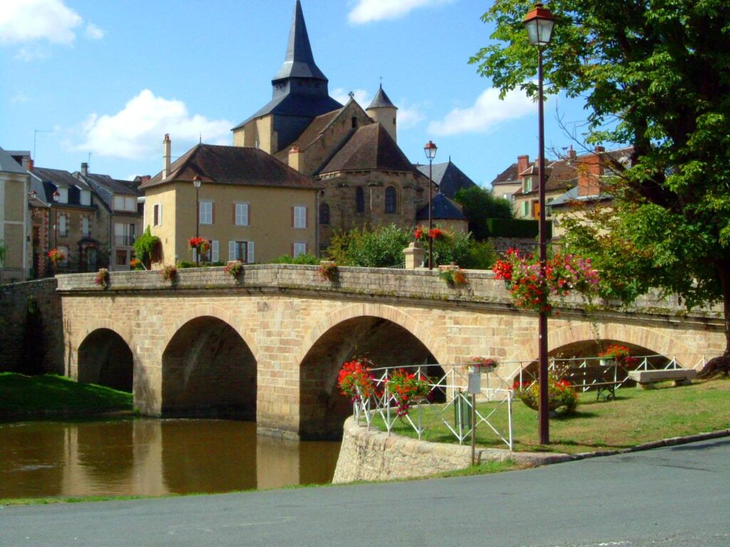 Beeld van La Celle Dunoise met op de voorgrond de rivier de Creuse en daarachter de kerk.